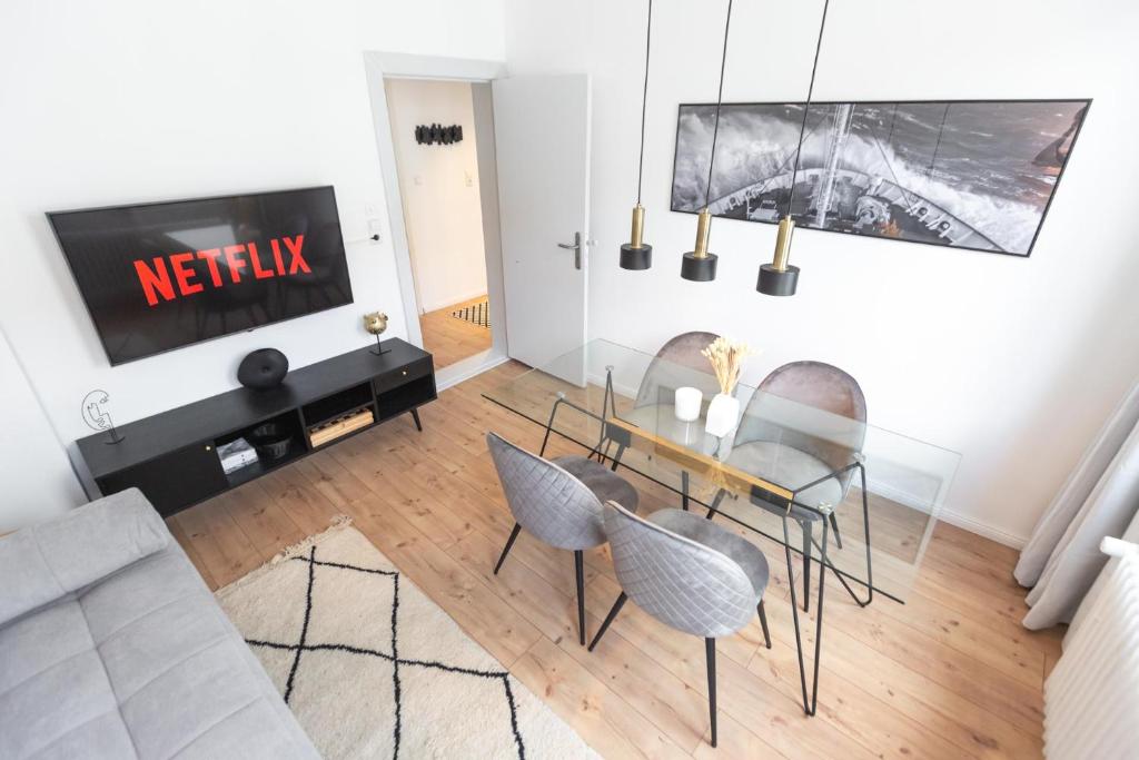 sala de estar con mesa de comedor y sillas en Bheaven I Explorer Premium Apartment, en Bremerhaven