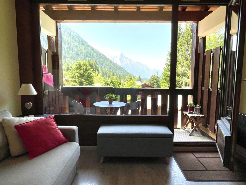 een woonkamer met een bank en een groot raam bij Residence La Verte 24- Aux Pieds des pistes! in Chamonix-Mont-Blanc