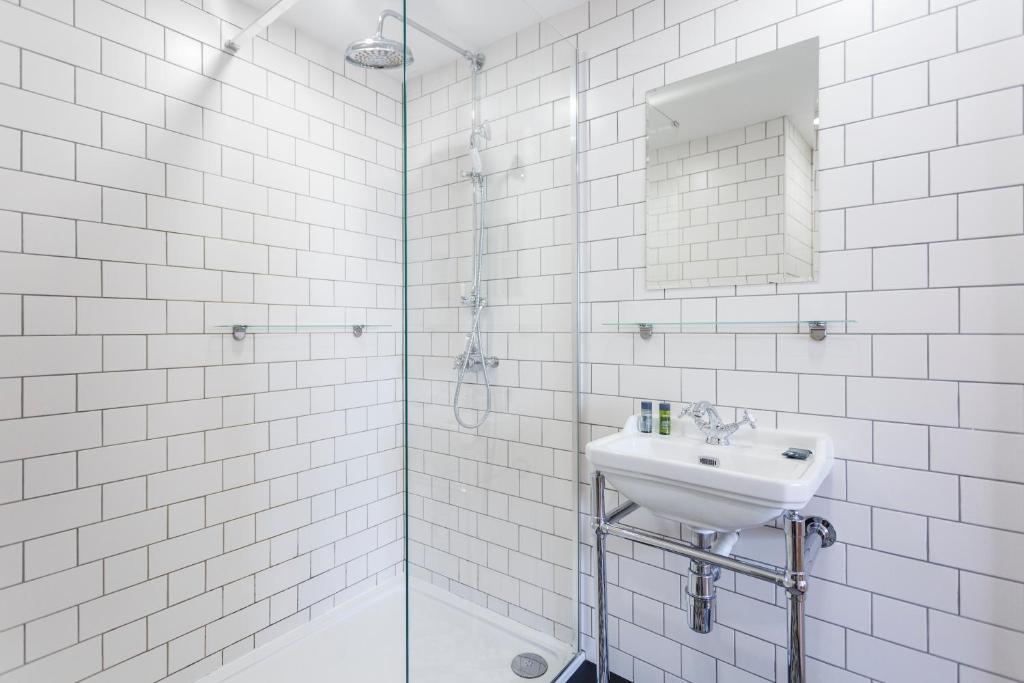 a white bathroom with a sink and a mirror at The Beetroot in Margate