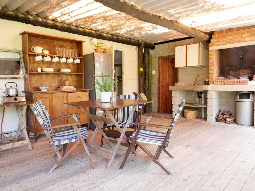 Milkwoodbend Farm Resort في شرق لندن: مطبخ مع طاولة وكراسي خشبية