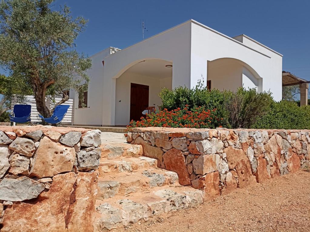 a stone retaining wall in front of a house at Tenuta Cazzato in Lido Marini