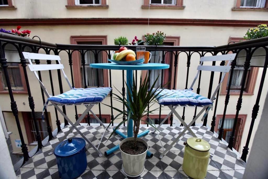 two chairs and a table with a plate of fruit on a balcony at Heristage Istanbul in Istanbul