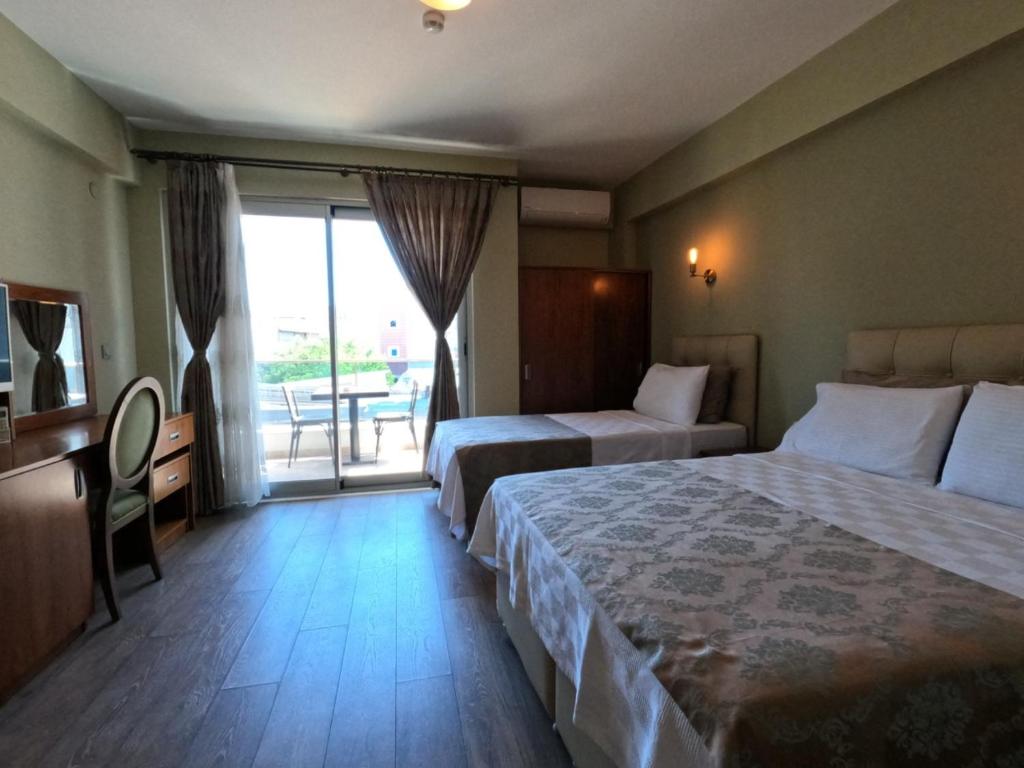 アーブシャ島にあるAlâ Avsa Hotelのベッド2台とバルコニーが備わるホテルルームです。