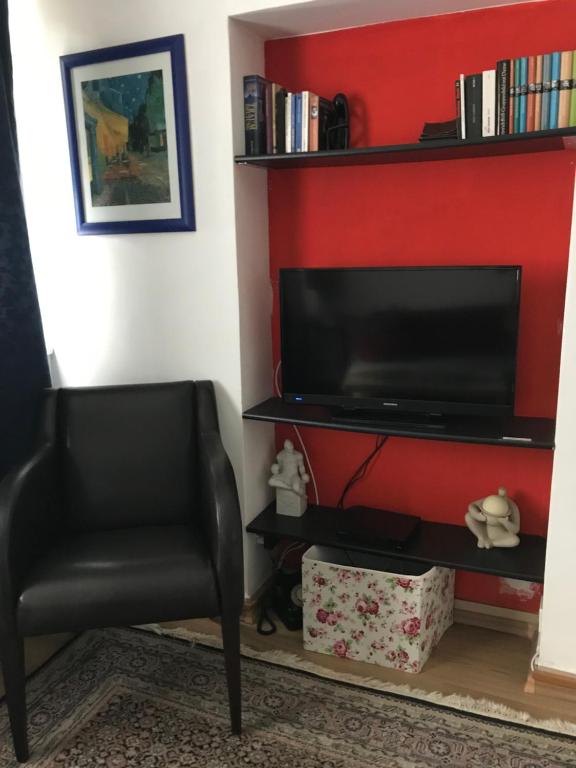 エッセンにあるNoch Gemütlicherの赤い壁のリビングルーム(テレビ、椅子付)
