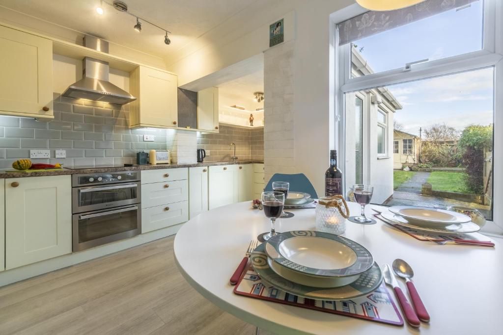 a kitchen with a table with glasses of wine at Hideaway Cottage in Leiston