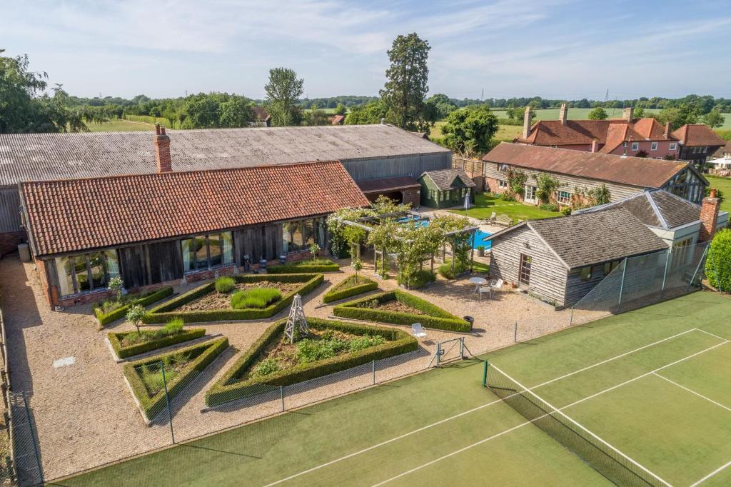 an aerial view of a house with a tennis court at Court Barn in Stoke-by-Nayland