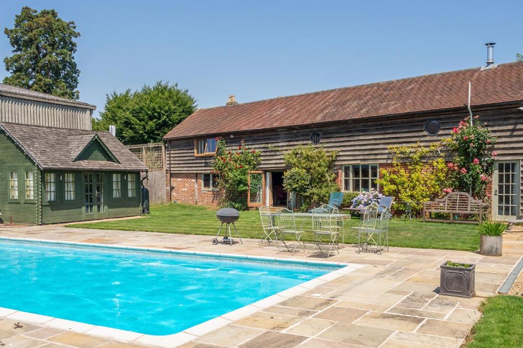 a house with a swimming pool in front of a house at Rose Barn in Stoke by Nayland