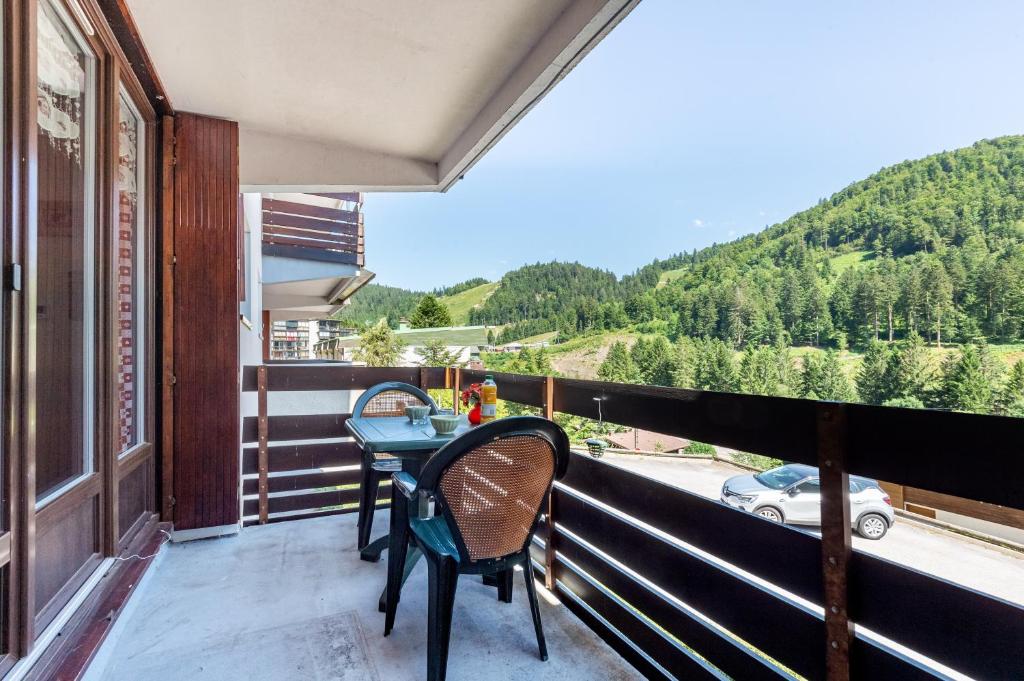 un balcon avec une table et des chaises et une vue dans l'établissement Le Montagnard, à La Bresse