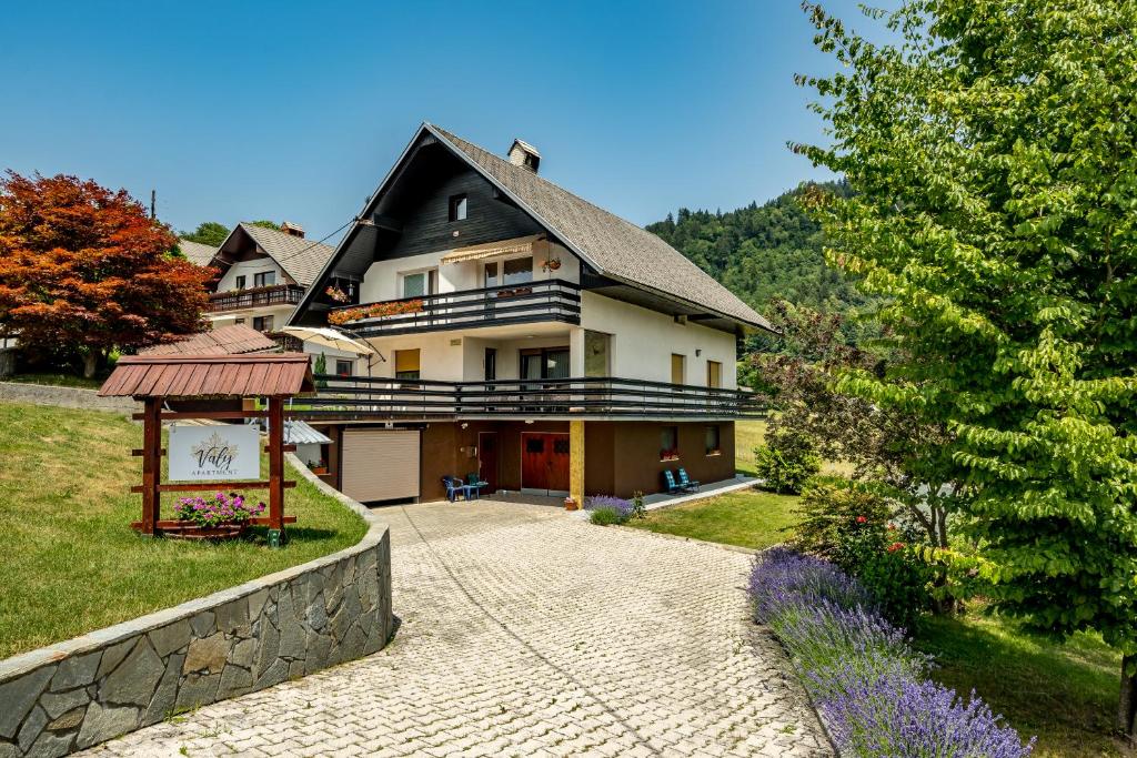 a large house with a stone walkway in front of it at Apartment Valy - big terrace & free bikes in Bled