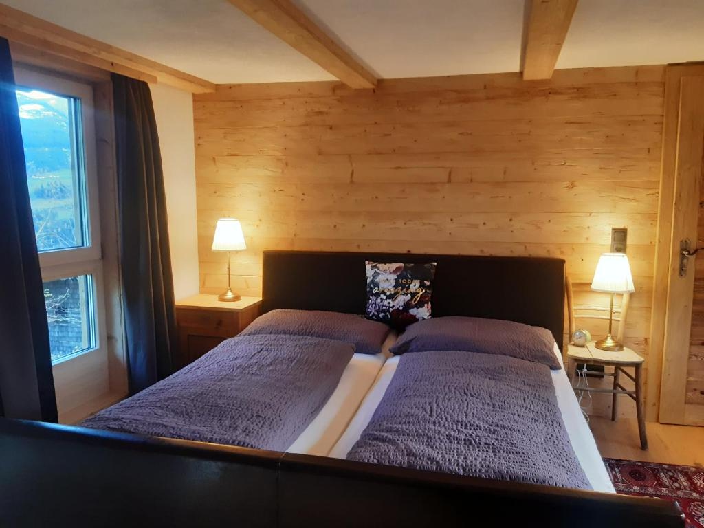 een slaapkamer met 2 bedden en 2 lampen op tafels bij Hüttenzauber in Taxenbach