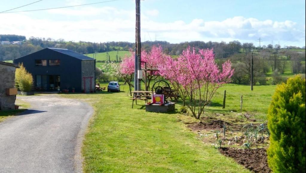 una casa al lado de una carretera con árboles rosas en LE PUY DU FOU A ENVIRON 5 KM GÎTE 6 PERSONNES en Chambretaud