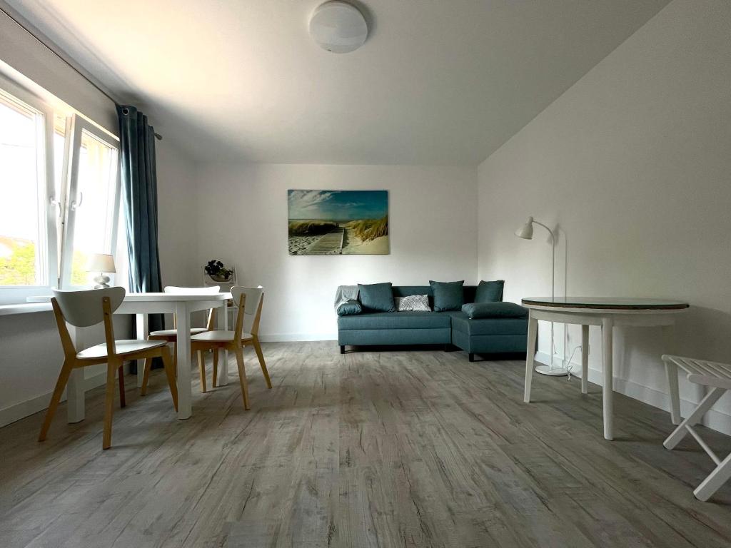 a living room with a blue couch and a table at Złota Rybka in Rewa