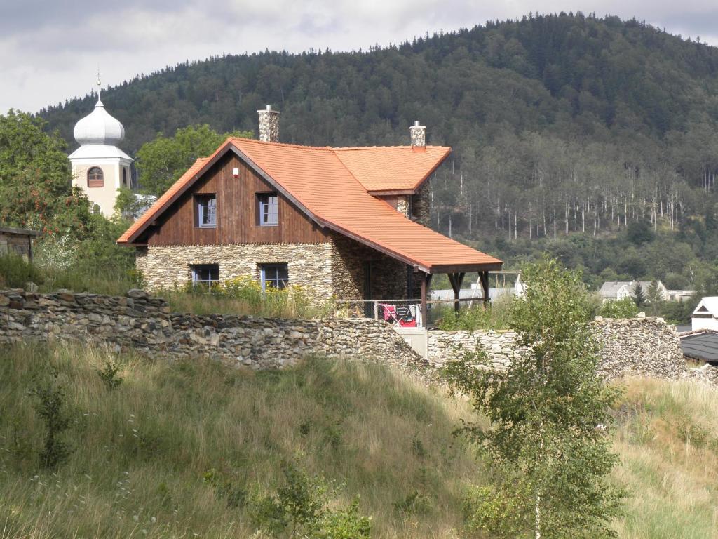 ein Haus mit einem orangenen Dach auf einem Hügel in der Unterkunft Skalny Dom in Stronie Śląskie