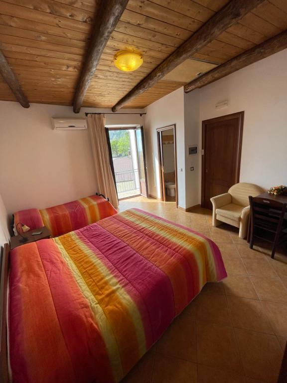 een slaapkamer met een groot bed en een kleurrijke deken bij B&B Antica Locanda San Ciriaco in Buonvicino