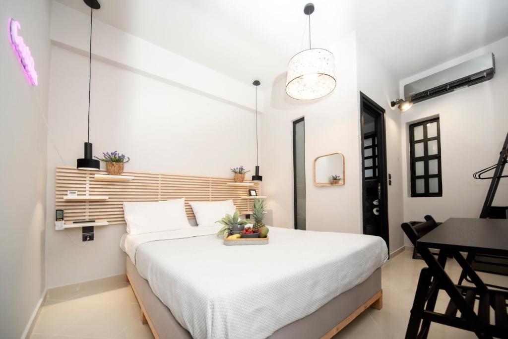 Un dormitorio con una gran cama blanca y una mesa en Urban Cosy Minimal Nest, en Chalkida