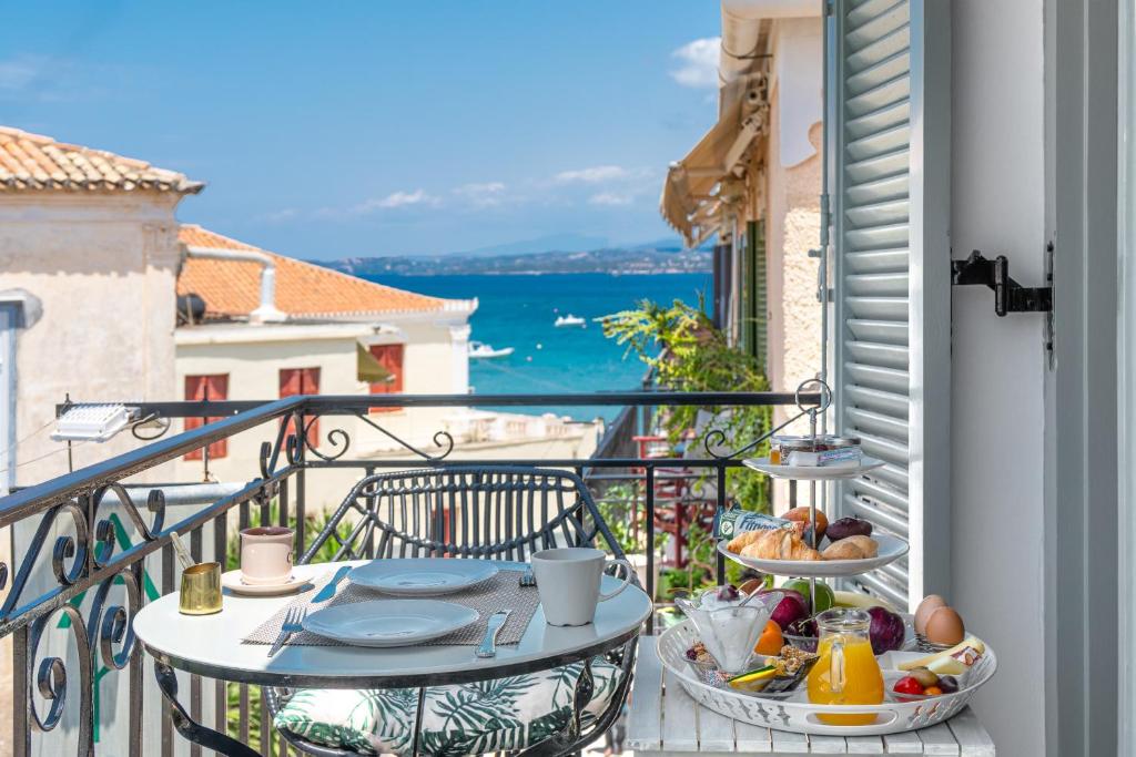 un balcone con tavolo e cibo sopra di Arolithos a Spetses
