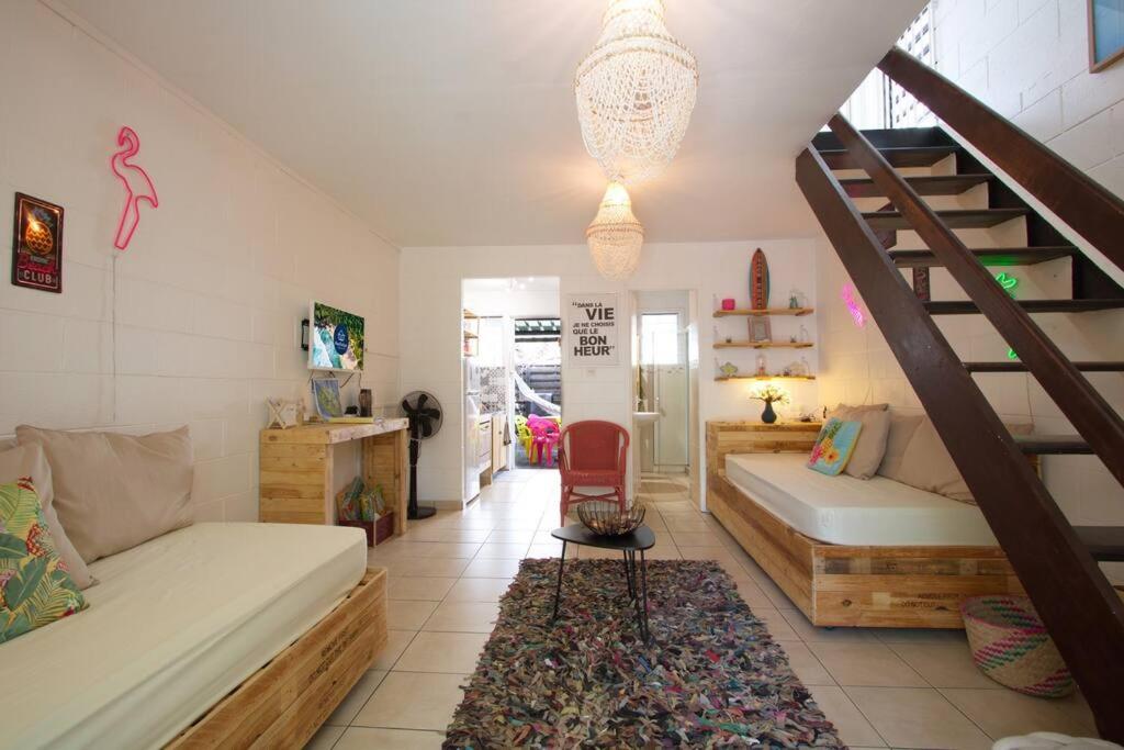 ein Wohnzimmer mit 2 Betten und einer Treppe in der Unterkunft Kaz Lotis - à 50m de la plage Roches Noires in Saint-Gilles-les-Bains