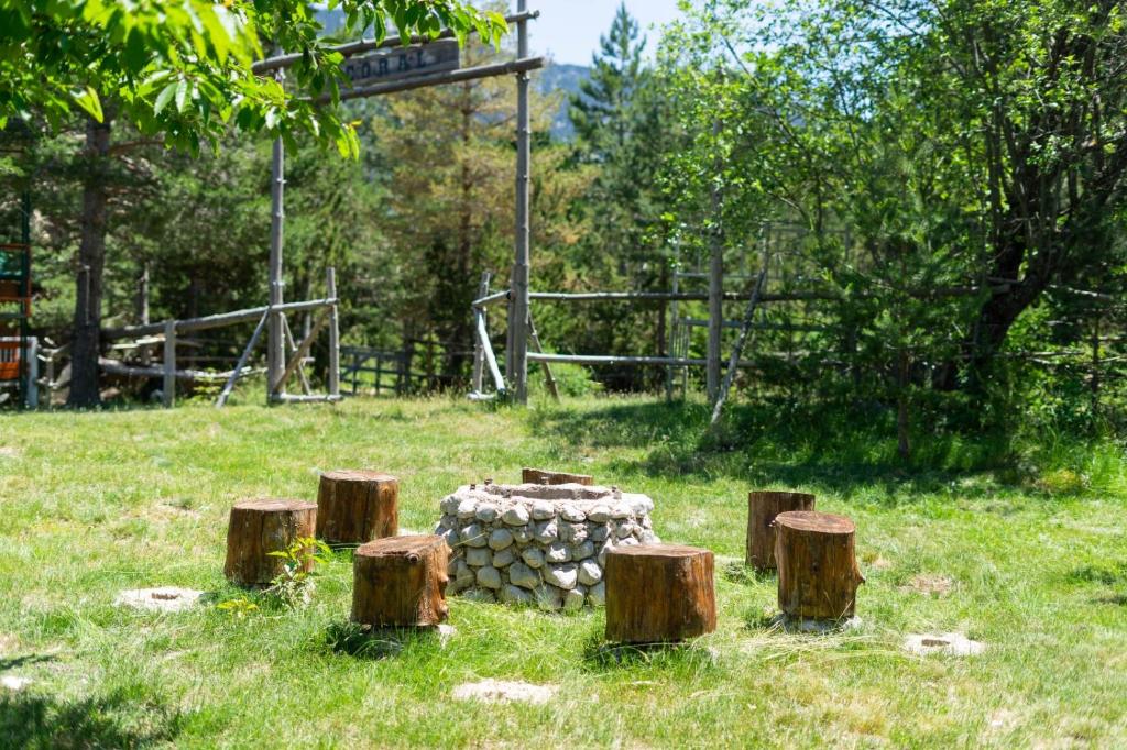 a pile of logs sitting in a field with trees at Apartment Blidinje, Ranch Mikulic in Blidinje