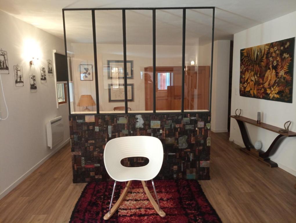 ein weißer Stuhl in einem Zimmer mit einem Teppich in der Unterkunft Thuir: superbe appartement in Thuir