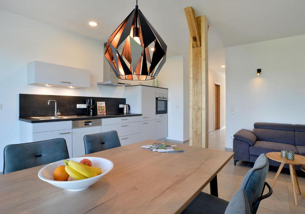 a kitchen with a wooden table with a bowl of fruit on it at Ferienwohnungen Am Aller-liebsten in Düngenheim