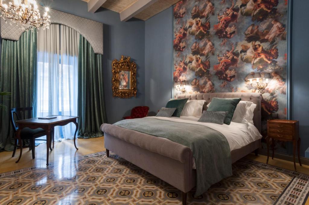 a bedroom with a large bed and a painting on the wall at The Coleridge Boutique Hotel In Valletta in Valletta