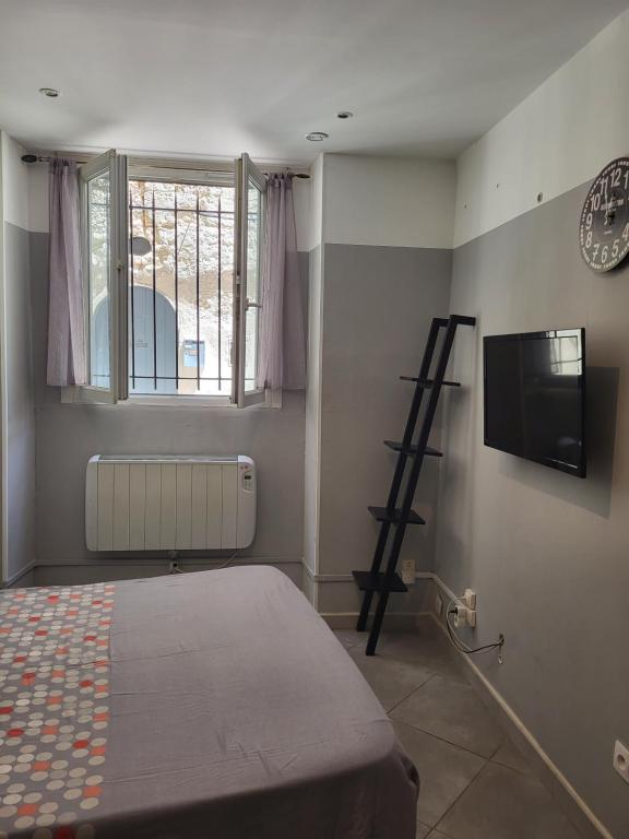 Cette chambre dispose d'un lit, d'une télévision et d'une échelle. dans l'établissement otela delacure, à Arles