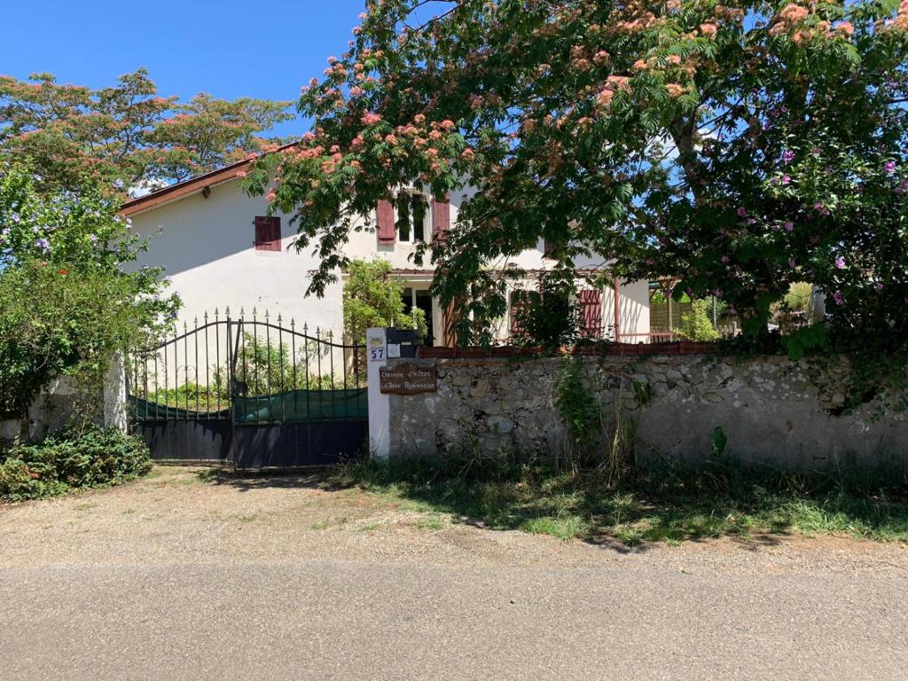 een wit huis met een hek en een boom bij la petite Poyannaise in Poyanne