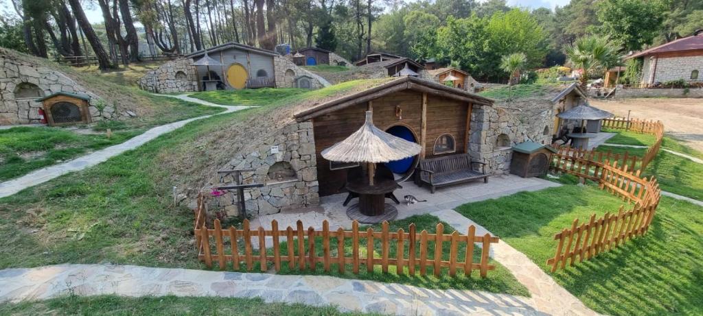 un modelo de una pequeña casa con una valla en Olympos Toprak evleri Earth houses, en Kumluca