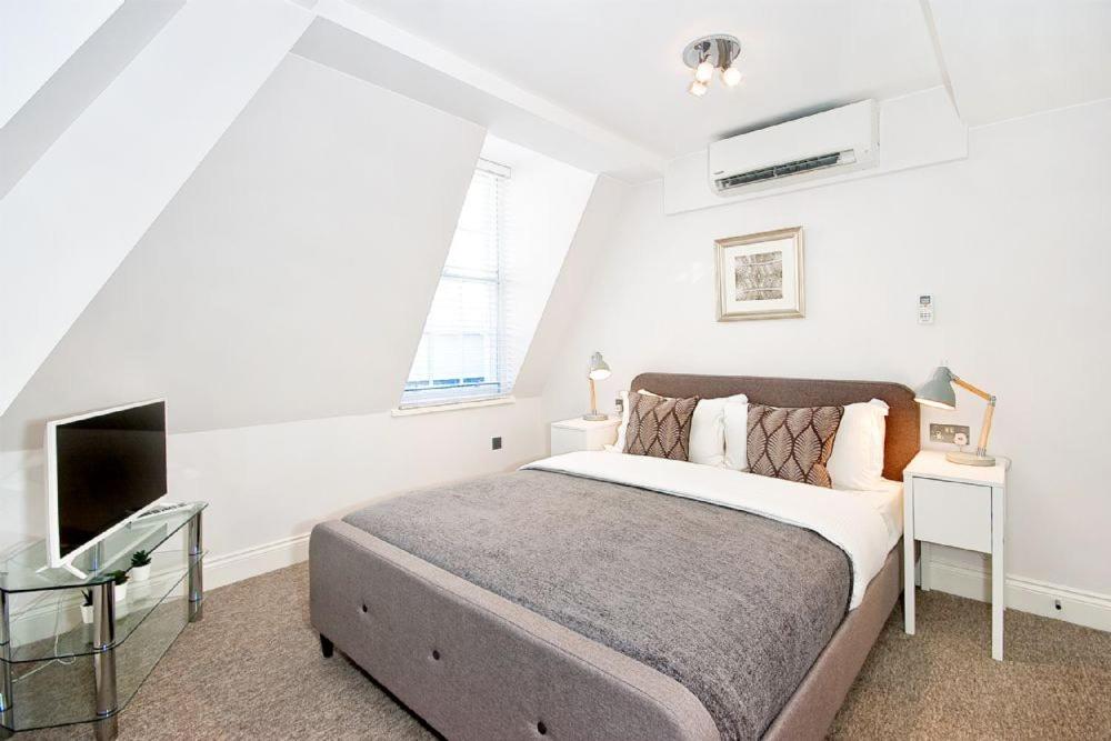 a bedroom with a large bed and a tv at Eldon Chambers Flat 1 by City Living London in London