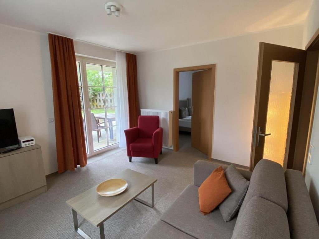 Landhaus Weißig & Rathen في Weißig: غرفة معيشة مع أريكة وكرسي احمر