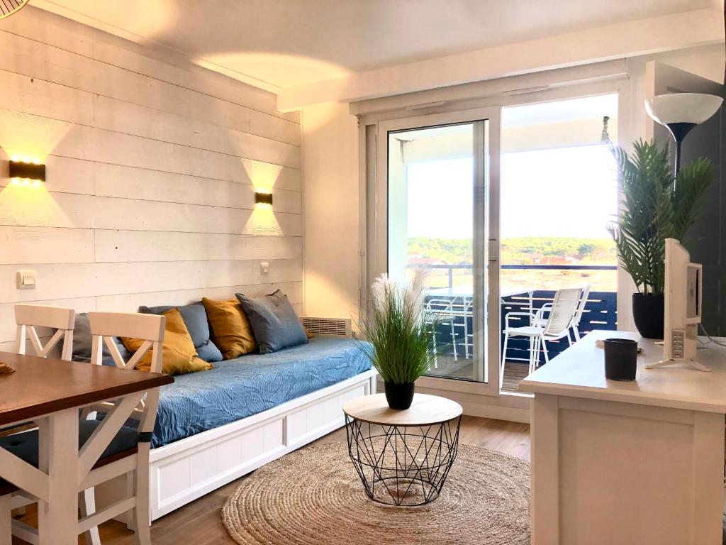 un salon avec un canapé et une table dans l'établissement Sympathique appartement en bord d'océan, à Lacanau