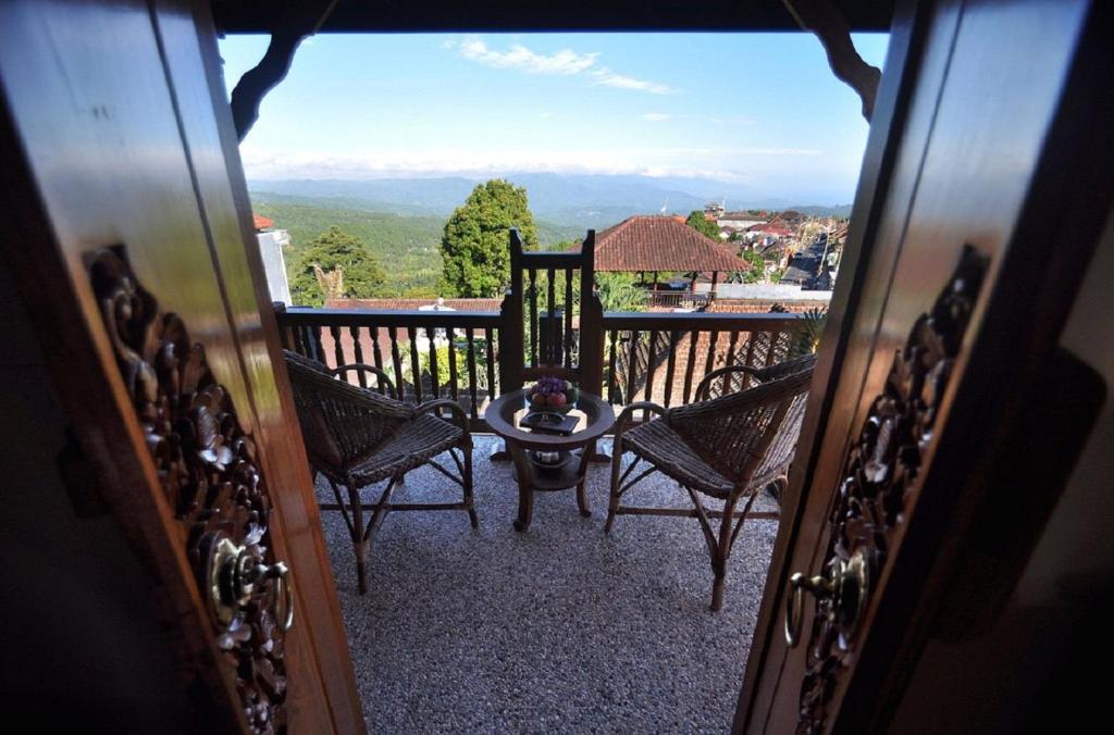 mit Blick auf einen Balkon mit Stühlen und einem Tisch in der Unterkunft Meme Surung Guesthouse in Munduk