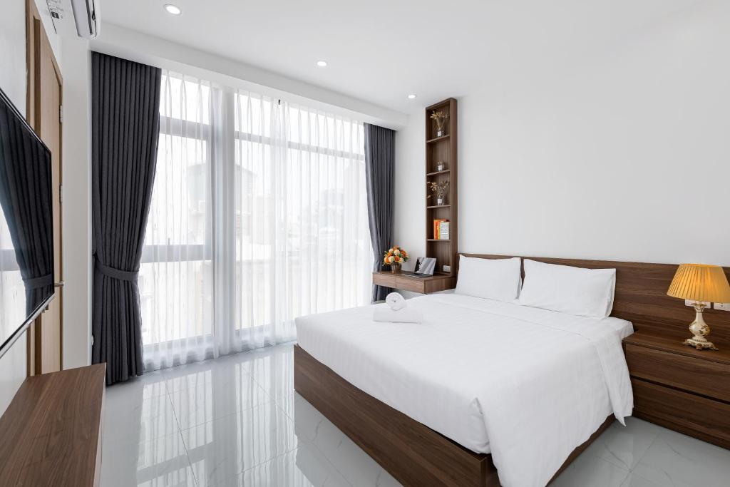 ein Schlafzimmer mit einem weißen Bett und einem großen Fenster in der Unterkunft Lakeside House 2 in Hanoi