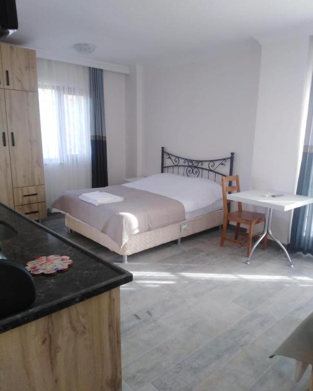 a bedroom with a bed and a table and a chair at Nur Konak daire 3 in Çanakkale