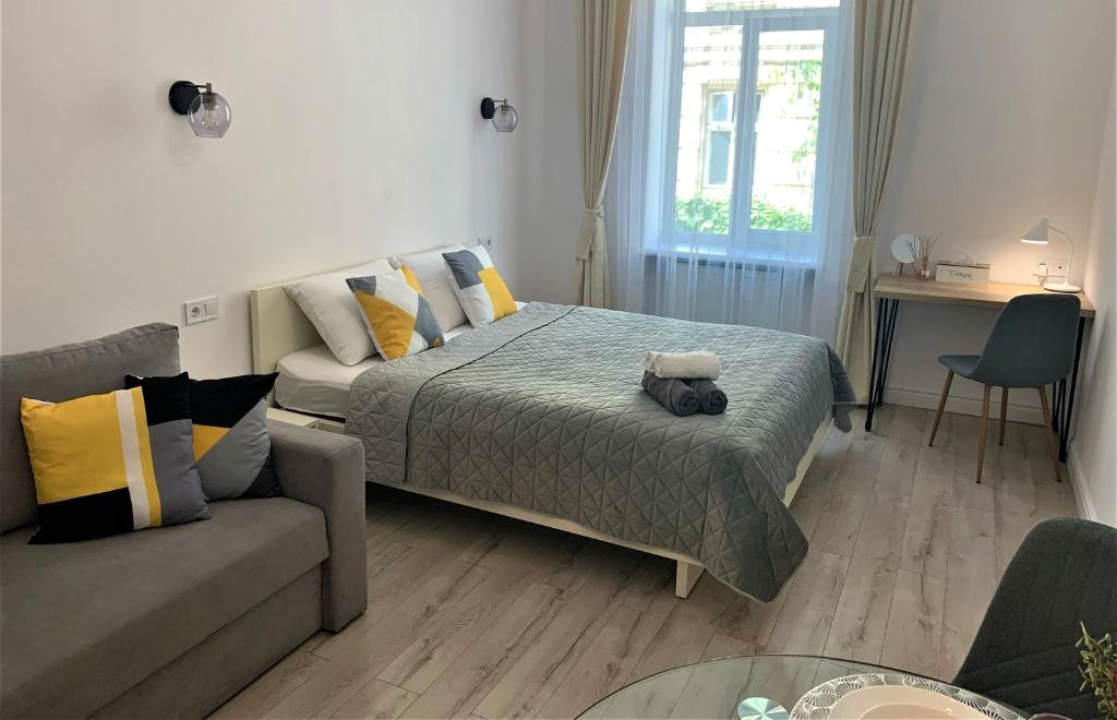 a bedroom with a bed and a couch at Iris apartment on Popovich in Lviv
