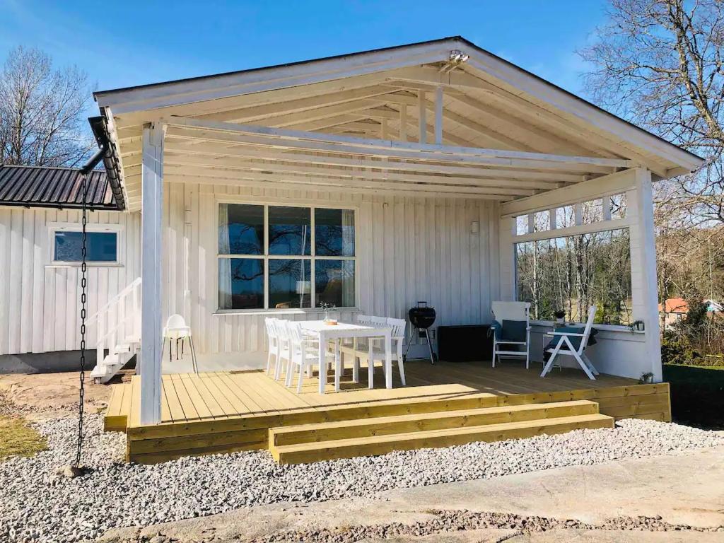 uma pequena casa branca com uma mesa e cadeiras em Panoramablick - Meer - Familien - Remote Work em Fjällbacka
