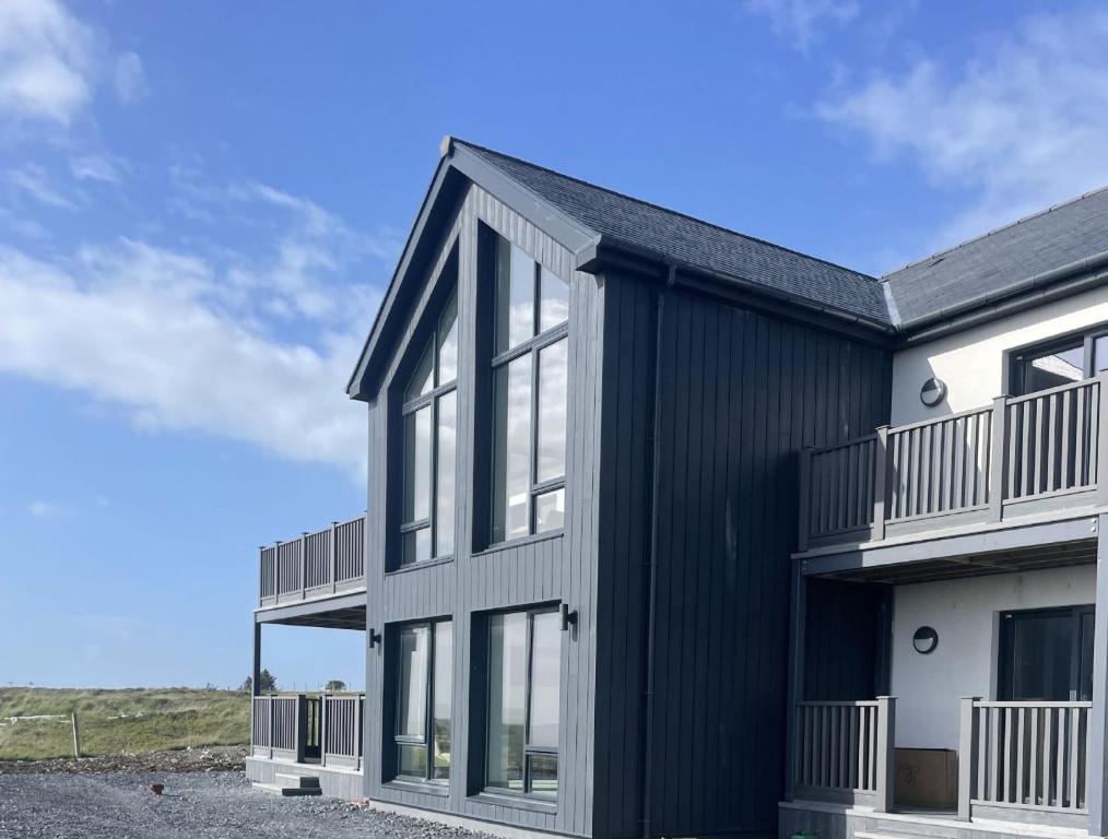 an exterior view of a black and white house at Machrie View in Port Ellen