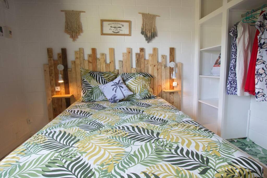 sypialnia z dużym łóżkiem z kolorową kołdrą w obiekcie Kaz Nomia - à 50m de la plage Roches Noires w mieście Saint-Gilles les Bains