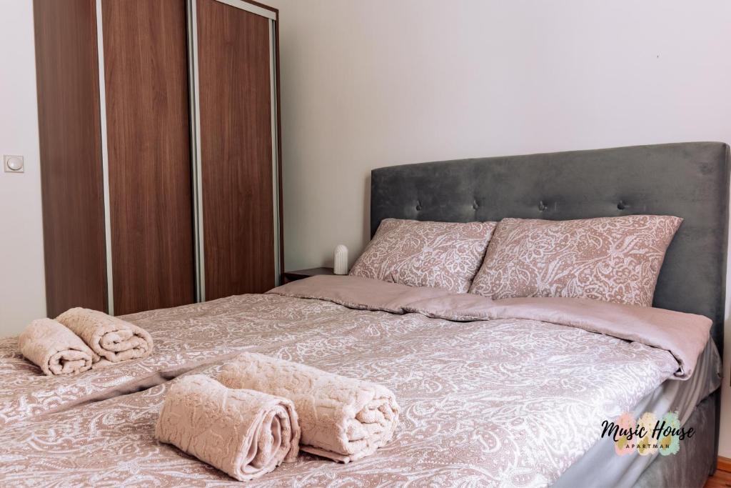 sypialnia z łóżkiem z różowymi kocami i poduszkami w obiekcie Music House Apartment w mieście Tuzla