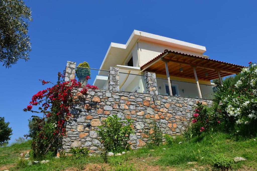a house on top of a stone wall at Melina Skiathos in Kolios