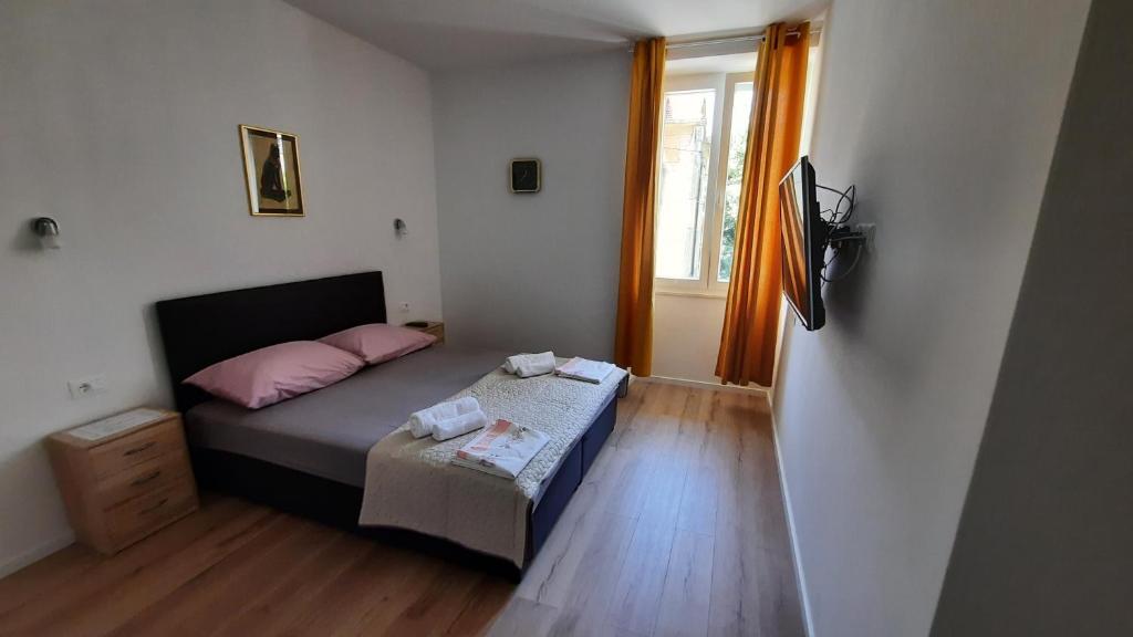 a small bedroom with a bed and a window at Cherry in Split