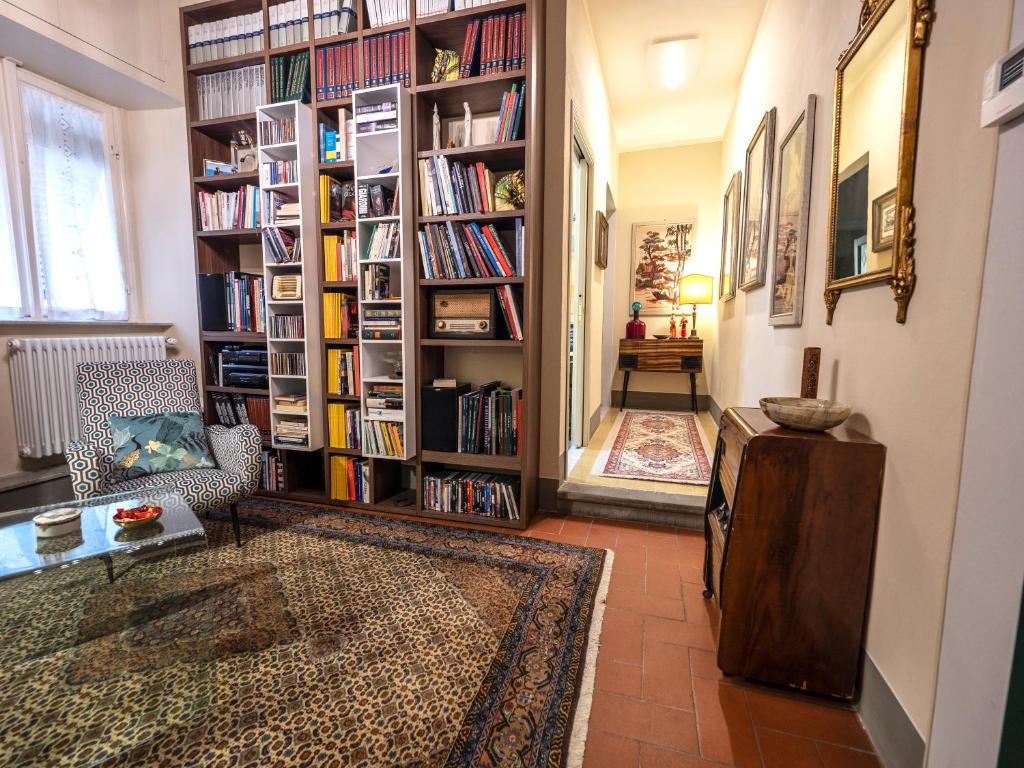 uma sala de estar com uma grande prateleira cheia de livros em LUXURY - Elegante appartamento nel cuore di Lucca em Lucca