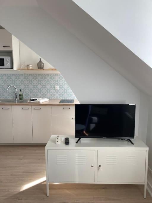 a living room with a tv on a white cabinet at Studio neuf Pont-rousseau Rezé in Rezé