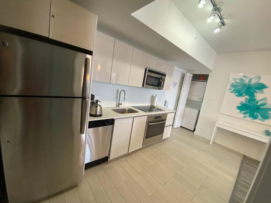 uma cozinha com um frigorífico de aço inoxidável e um lavatório em Apartment 1B-1B Amazing View BW 30A em Hallandale Beach