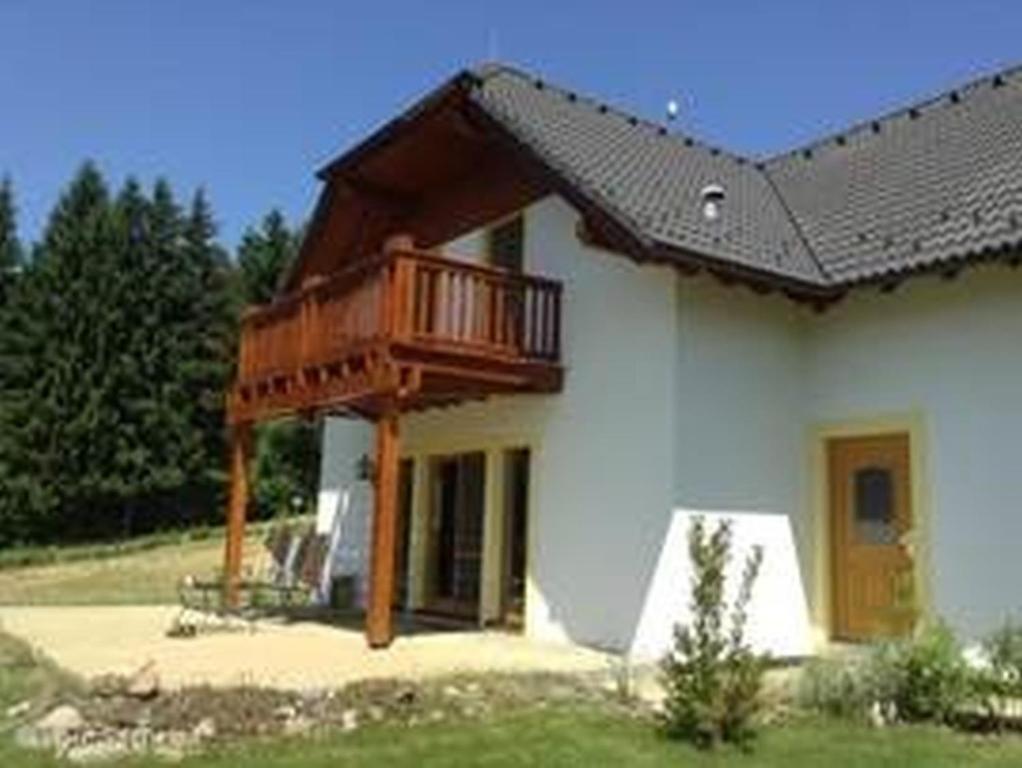 una casa con un balcón en el lateral. en Villa Gamma - Lipno Home, en Lipno nad Vltavou