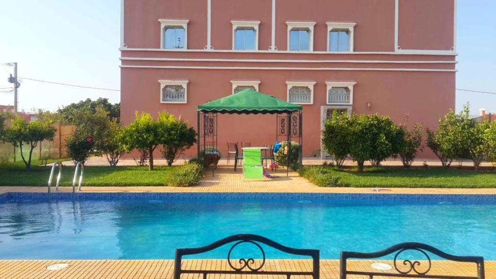 a house with a swimming pool in front of a building at 4 bedrooms villa with private pool and enclosed garden at Tou Ganaou in Ti nʼ Saïd