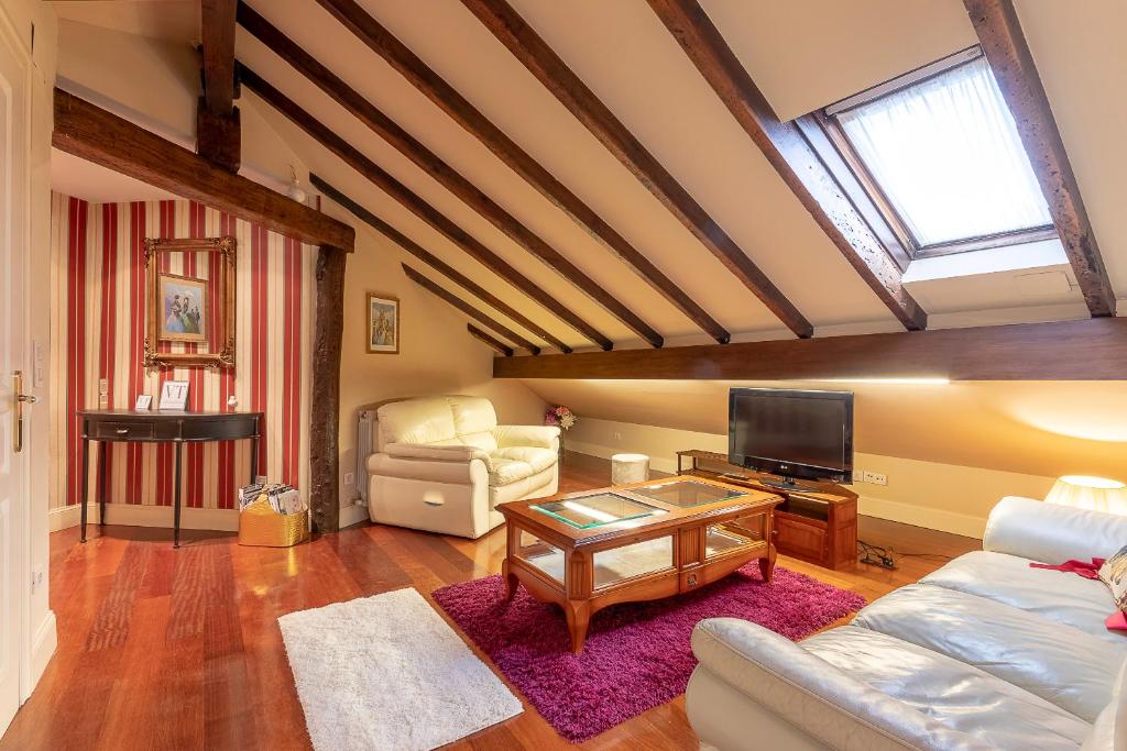 uma sala de estar com um sofá e uma televisão em Vizcaya Bridge & Beach em Getxo