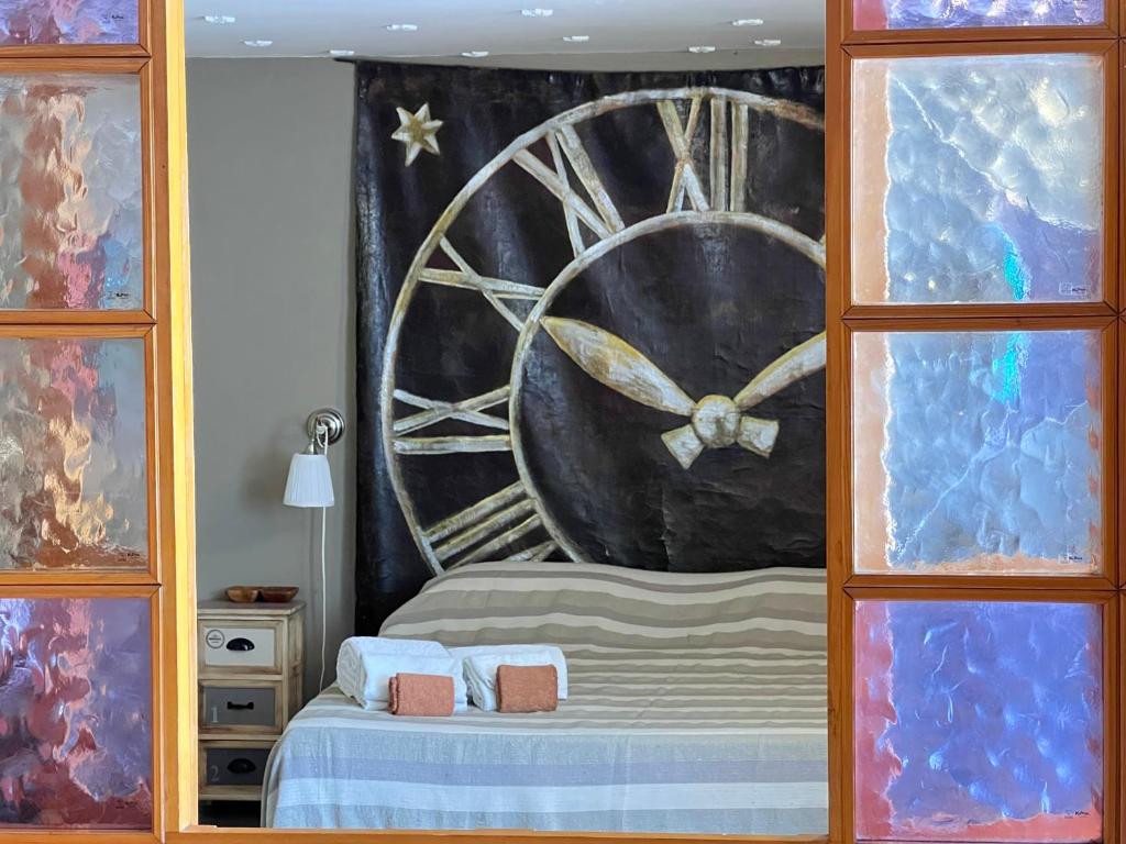 1 dormitorio con 1 cama y reloj grande en B&B Borgo, en Ventimiglia