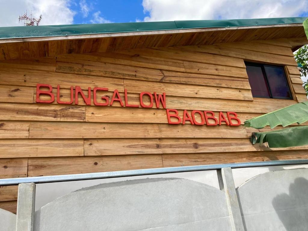 ein Schild an der Seite eines Holzgebäudes in der Unterkunft Bungalows Baobab in San Isidro