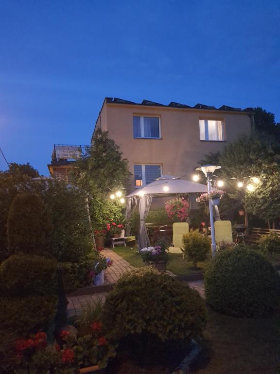 uma casa com um jardim à noite com luzes em u eli i jurka em Sztutowo